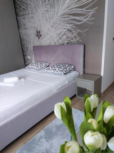 a small bedroom with a bed and a table at Paula Apartment in Dumbrăviţa