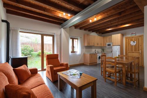 ein Wohnzimmer mit einem Sofa und einem Tisch sowie eine Küche in der Unterkunft Apartamentos Bores in Bores