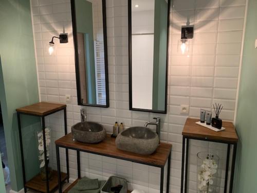 La salle de bains est pourvue de 2 lavabos et de 2 miroirs. dans l'établissement BnB De Koepoort, à Malines