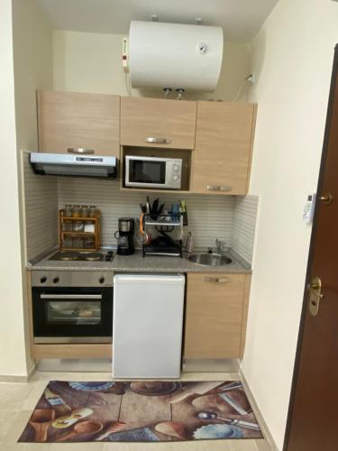 a small kitchen with a sink and a microwave at Appartement S 1 résidence les Dunes sousse avec piscine in Sousse