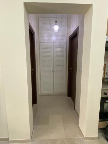 a hallway with white walls and white doors at Appartement S 1 résidence les Dunes sousse avec piscine in Sousse