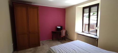 a bedroom with a bed and a window and a desk at La Diligence in Arsdorf