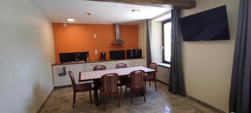 a kitchen with a table and chairs in a room at La Diligence in Arsdorf