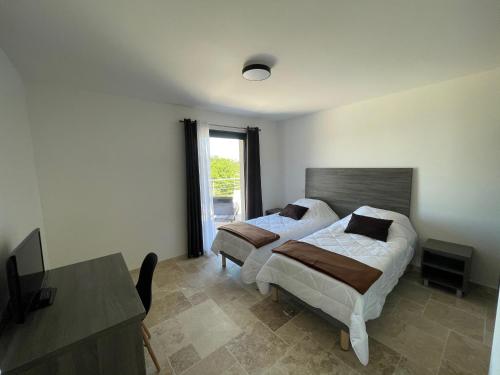 - une chambre avec 2 lits, une table et une fenêtre dans l'établissement Gîte du point de vue, à Autoire
