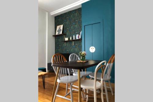 uma sala de jantar com paredes azuis e uma mesa e cadeiras em Le songe d'Etigny em Luchon