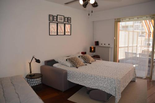 une chambre avec un lit, un canapé et une fenêtre dans l'établissement Grand studio climatisé proche plages Juan les pins, à Antibes