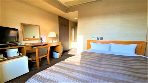 Säng eller sängar i ett rum på Hotel Route-Inn Tsuruoka Inter