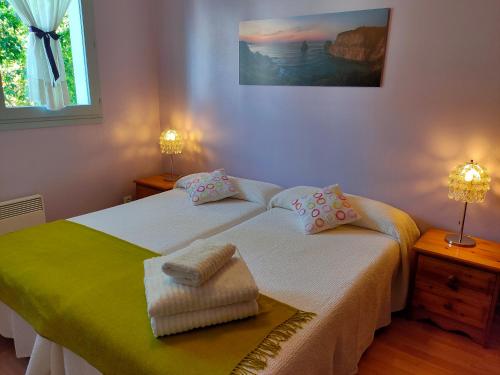 une chambre avec deux lits avec des serviettes dessus dans l'établissement Relax, silencio y sol en el jardin, à Hendaye