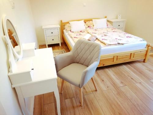 a bedroom with a bed with a chair and a desk at Elisoria Apartments in Cserszegtomaj