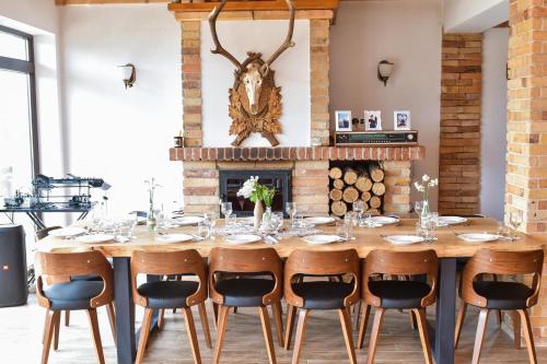 a dining room with a table with chairs and a fireplace at PANORAMIC Sus In Deal in Vişeu de Jos