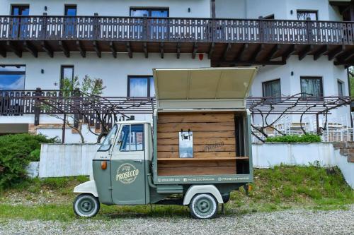 a small green truck parked in front of a building at PANORAMIC Sus In Deal in Vişeu de Jos