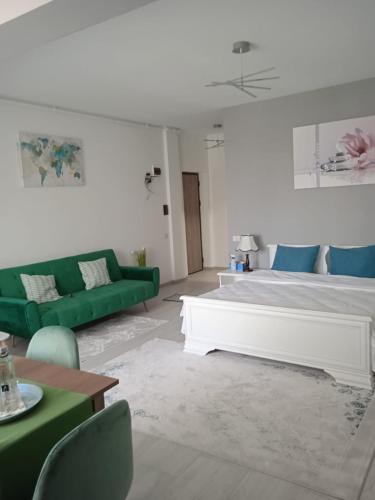 a living room with a bed and a green couch at Studio Timeea Mamaia-Nord in Năvodari