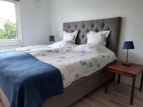 a bedroom with a large bed with a blue blanket at Centralt i Falkenberg in Falkenberg