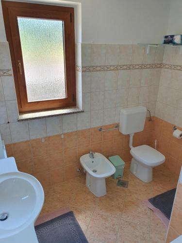 uma casa de banho com um WC, um lavatório e uma janela em Apartments Palma em Rovinj