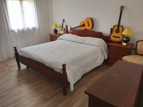 una camera da letto con un letto con chitarre appese al muro di Ottavanota a Bassano del Grappa