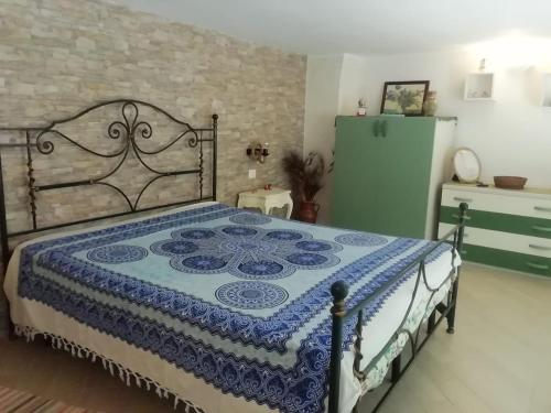 um quarto com uma cama com um edredão azul e branco em casa maravigghia em Catânia