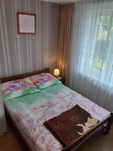 a bed in a bedroom with a window with avertisement at Dom Gościnny "BASIA" in Jastrzębia Góra