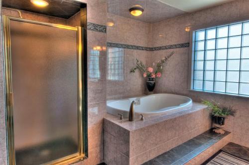 baño grande con bañera y ventana en MCM Elegante Suites Abilene, en Abilene