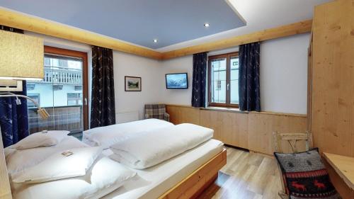 a bedroom with two white beds and a window at Haus Lina in Sankt Anton am Arlberg