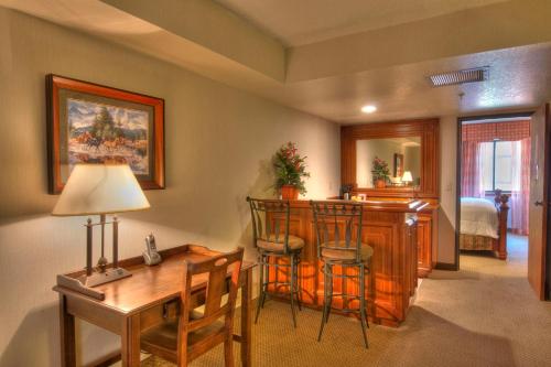 a living room with a kitchen and a desk with chairs at MCM Elegante Suites Abilene in Abilene