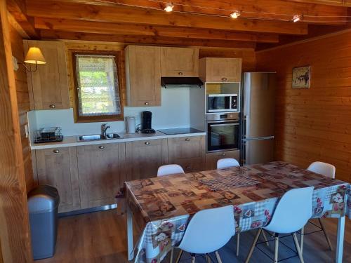 uma cozinha com uma mesa e cadeiras num camarote em Chalet Sancy em Saint-Genès-Champespe