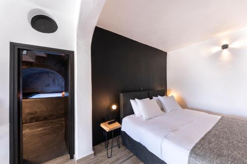 a hotel room with a bed and a window at Pearl of Caldera Oia - Boutique Hotel by Pearl Hotel Collection in Oia