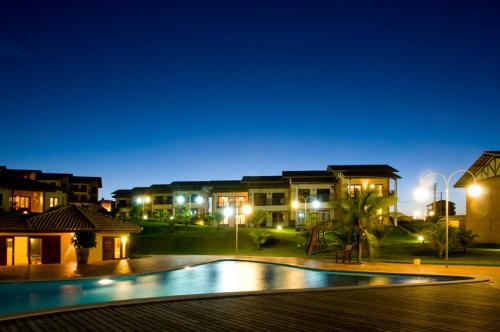 - une vue nocturne sur un complexe avec une piscine dans l'établissement Condomínio Encantador Piscina e Praia E12, à Zumbi