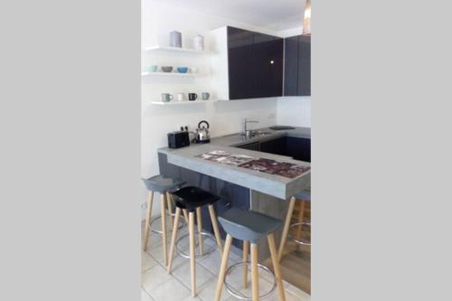 une cuisine avec un comptoir bleu et des tabourets dans l'établissement Charmant T2 avec vue sur le port, à Vannes