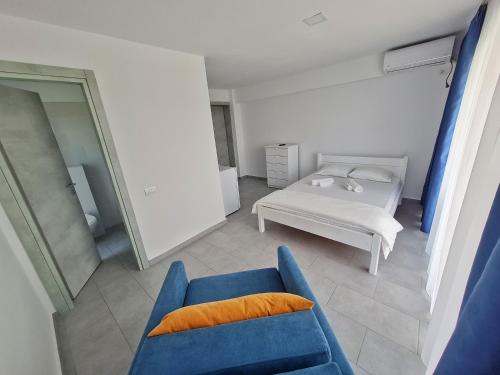 a living room with a blue couch and a bed at Waterman in Costinesti