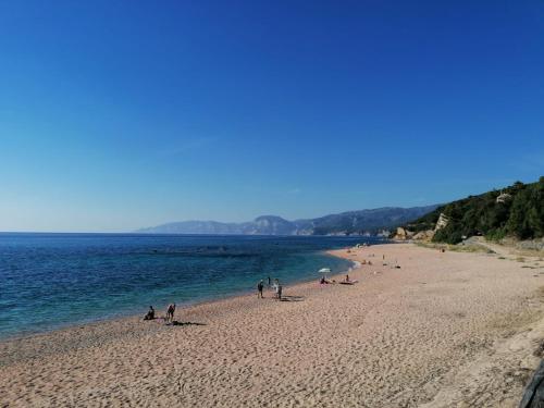 a group of people on a beach near the water at Luna e Mare in Cala Gonone