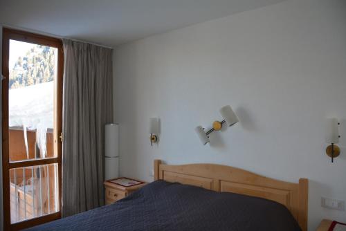 een slaapkamer met een bed en een groot raam bij Casa Sonia in Canazei