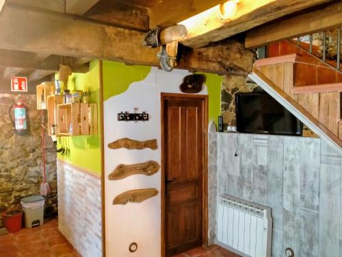 a room with a door and a wall with wooden beams at Casa con encanto in Aller