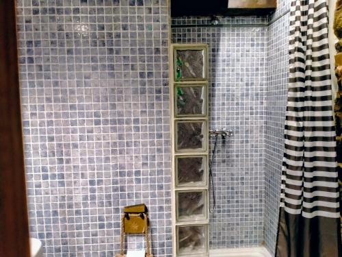 a shower with glass shelves in a blue tiled wall at Casa con encanto in Aller