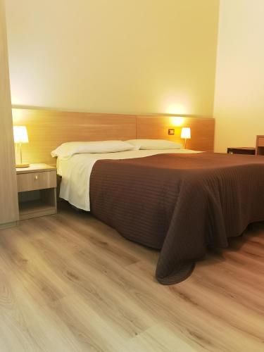 a hotel room with a large bed and wooden floors at Villa Astoria in Taormina