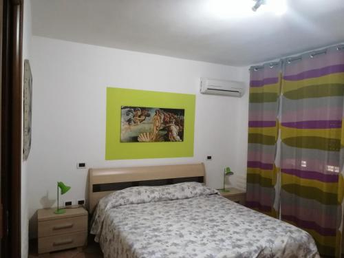 a bedroom with a bed and a painting on the wall at La Vecchia Taverna B&B in Prignano Cilento