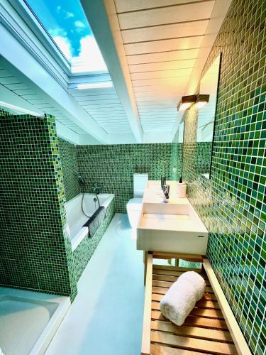 a bathroom with a sink and a bath tub at Beach House Es Trenc in Ses Covetes