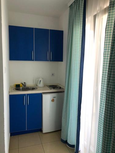 a small kitchen with blue cabinets and a sink at Villa Rihter in Budva