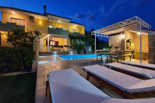 uma villa com piscina à noite em Beautiful villa - private heated pool, parking, BBQ near Split em Solin