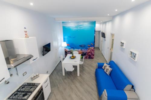 a living room with a blue couch and an aquarium at La casa nel vicolo 2 in Giardini Naxos