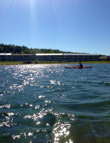 a person in a kayak on a body of water at Bavarian Haus Lakefront Inn in Saint Ignace
