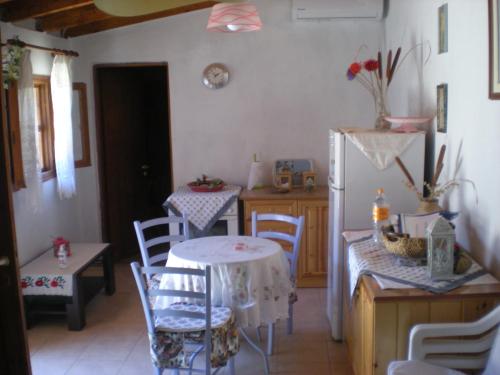 Petalidi Gedigio في بيتاليدهيون: مطبخ مع طاولة وكراسي وثلاجة