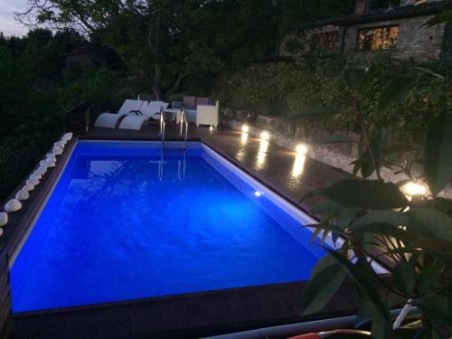 a swimming pool with blue water at night at Poggio al Sole in Fiesole