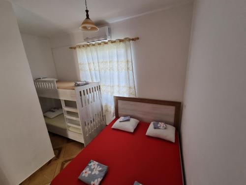 a small room with a crib and a red table at Roan Apartments in Velipojë