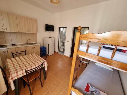 a room with a bunk bed and a kitchen with a table at Roan Apartments in Velipojë