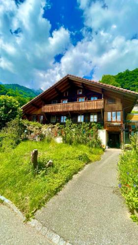 a house on a hill with a road in front of it at Charmant Chalet mit See und Bergsicht in Hofstetten 