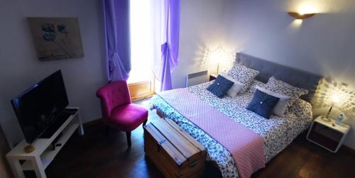 - une chambre avec un lit et une chaise rouge dans l'établissement L'AMARILYS chambre d'hôte, à Châteauneuf-du-Pape
