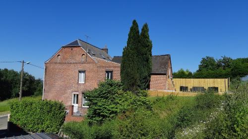 an old brick house with a tree in the yard at Les Hauts de Proisy in Proisy