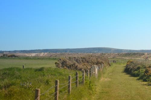 a fence on the side of a field at THE HIDEAWAY - LUXURY SELF CATERING COASTAL APARTMENT with PRIVATE ENTRANCE & KEY BOX ENTRY JUST A FEW MINUTES WALK TO THE BEACH, SOLENT WAY WALK, SHOPS and many EATERIES & BARS - FREE OFF ROAD PARKING,FULL KITCHEN, LOUNGE,BEDROOM , BATHROOM & WI-FI in Lymington