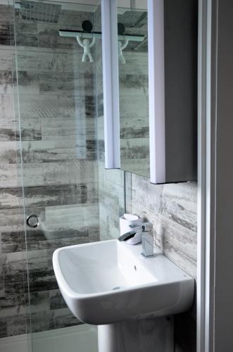a bathroom with a sink and a mirror at THE HIDEAWAY - LUXURY SELF CATERING COASTAL APARTMENT with PRIVATE ENTRANCE & KEY BOX ENTRY JUST A FEW MINUTES WALK TO THE BEACH, SOLENT WAY WALK, SHOPS and many EATERIES & BARS - FREE OFF ROAD PARKING,FULL KITCHEN, LOUNGE,BEDROOM , BATHROOM & WI-FI in Lymington