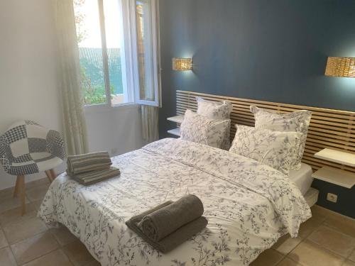une chambre avec un lit avec deux serviettes dessus dans l'établissement Arche de Portissol Sanary Appartement de charme 4 à 6 personnes, à Sanary-sur-Mer